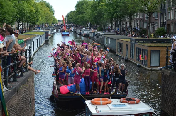 AMSTERDAM, NETHERLANDS - AUGUST 06, 2022: Many people in boats at LGBT pride parade on river