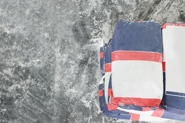 Cement powder in bags on stone floor, top view. Space for text