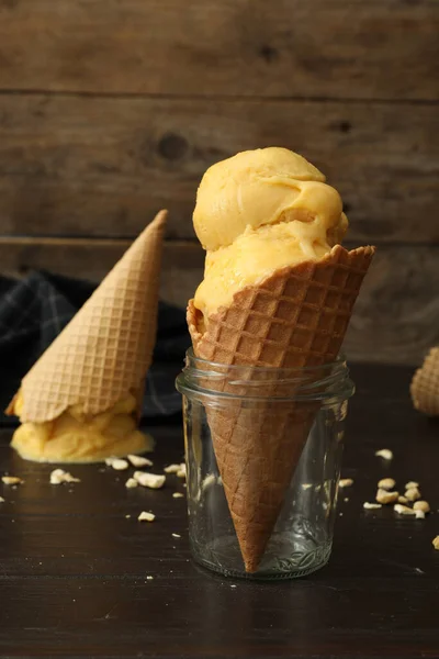 Вкусное Желтое Мороженое Вафельном Конусе Стеклянной Банке Черном Деревянном Столе — стоковое фото
