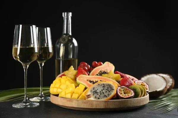 Ízletes Egzotikus Gyümölcsök Poharak Bor Fekete Asztalon — Stock Fotó
