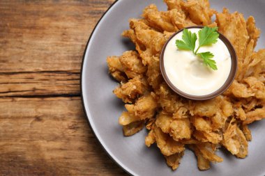 Ahşap masada servis edilen soslu soğan kızartması. Metin için boşluk