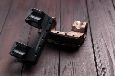 Quick disconnect sniper cantilever scope mounts on wooden table, closeup