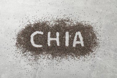 CHIA kelimesi tohum yığınına yazılmış gri masa, üst görünüm