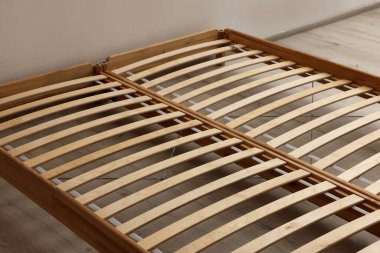 Wooden bed frame on floor in room, closeup view