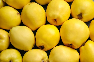 Fresh ripe organic quinces as background, closeup
