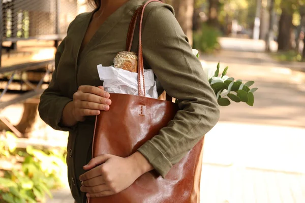 Woman with leather shopper bag on city street, closeup