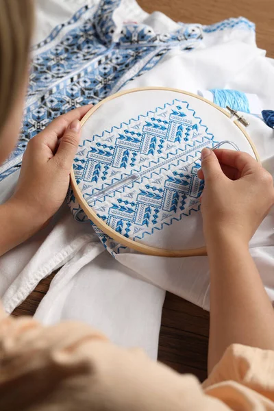 Woman Embroidering White Shirt Blue Thread Wooden Table Closeup Ukrainian — Fotografia de Stock