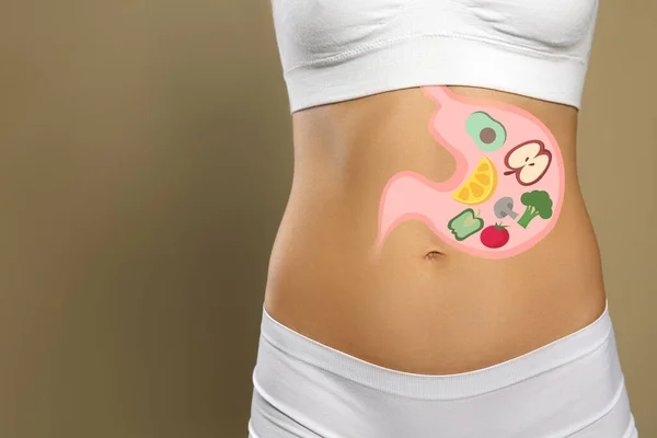 Woman with image of stomach full of food drawn on her belly against beige background, closeup. Healthy eating habits