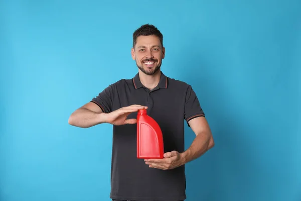 Man Holding Red Container Motor Oil Light Blue Background —  Fotos de Stock