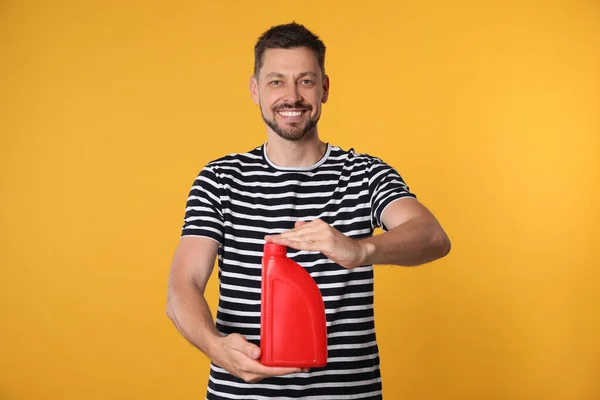 Man Holding Red Container Motor Oil Orange Background — 스톡 사진