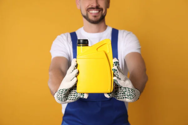 Man Showing Yellow Container Motor Oil Orange Background Closeup — Stockfoto