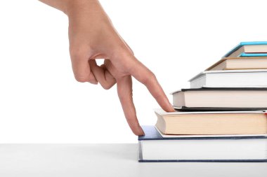 Woman imitating stepping up on books with her fingers against white background, closeup