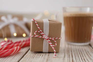 Christmas gift box and candy canes on white wooden table, closeup