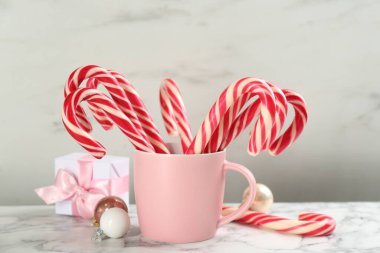 Candy canes and Christmas balls on white marble table
