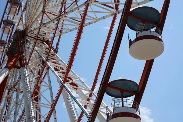 Beautiful Ferris wheel against blue sky on sunny day, low angle view