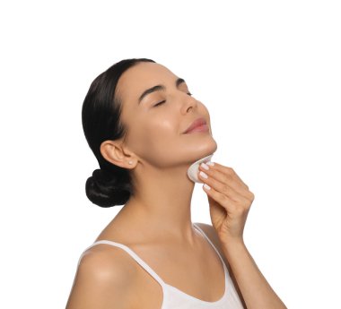 Young woman using cotton pad with micellar water on white background