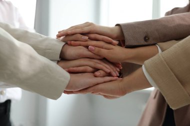 Group of people holding hands together indoors, closeup. Unity concept