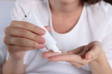 Woman applying cream from tube on hand, closeup