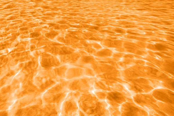 View on ocean water with ripples and flecks. Toned in orange