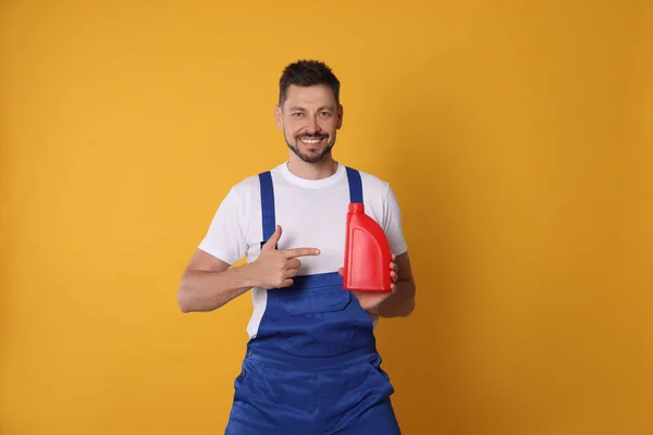 Man Pointing Red Container Motor Oil Orange Background — Stok fotoğraf