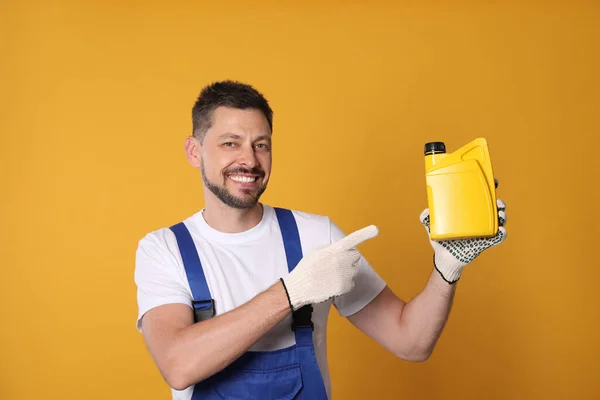 Man Pointing Yellow Container Motor Oil Orange Background — Stockfoto