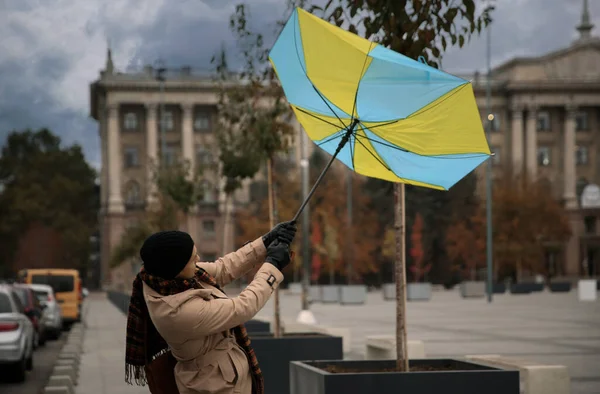Man with colorful umbrella caught in gust of wind on street
