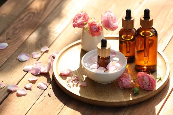 Flessen Van Rose Etherische Olie Bloemen Houten Tafel Ruimte Voor — Stockfoto