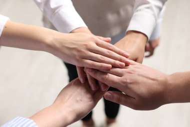 Group of people holding hands together indoors, above view. Unity concept