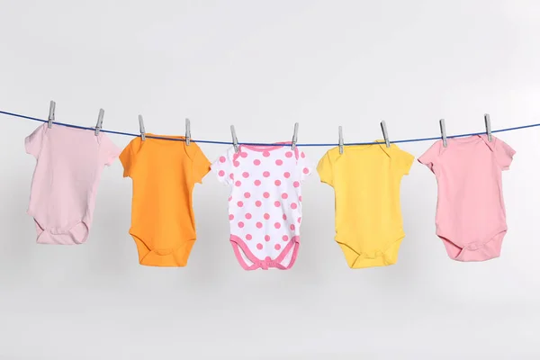 Colorful Baby Onesies Drying Laundry Line Light Background — Stok fotoğraf