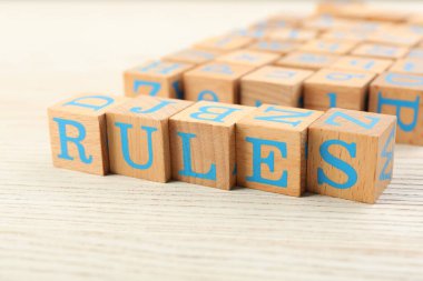 Word Rules made of cubes with letters on light wooden table