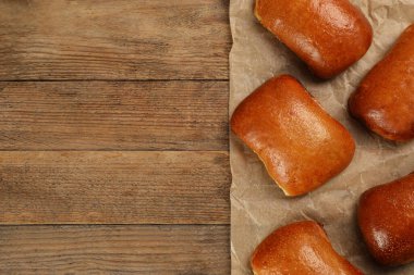Ahşap masada nefis pişmiş pirozhki, düz yatıyordu. Metin için boşluk