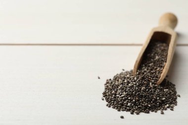 Beyaz ahşap masada chia tohumlarıyla kepçe. Metin için boşluk