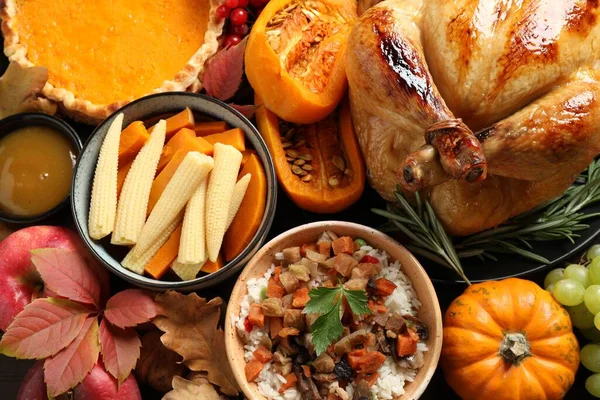 Traditional Thanksgiving day feast with delicious cooked turkey and other seasonal dishes as background, top view