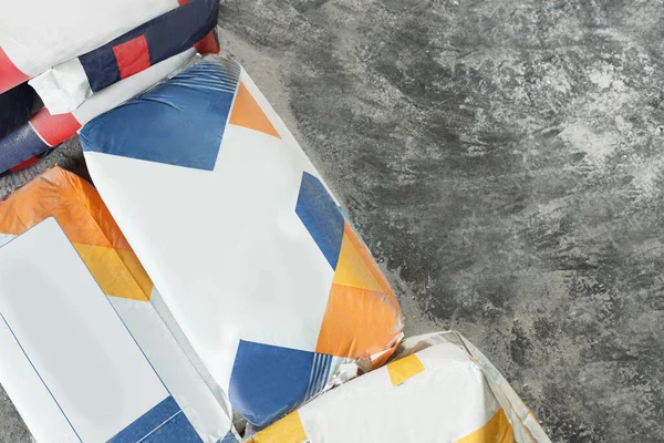 Cement powder in bags on stone floor, top view. Space for text