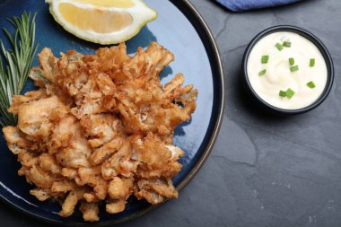 Siyah masada limon ve sosla servis edilen nefis soğan çiçeği.