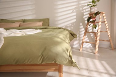 Şık oda içinde yumuşak battaniyeli büyük bir yatak.