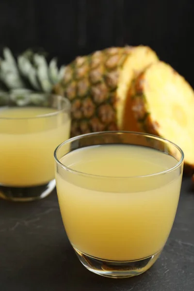Delicious fresh pineapple juice on black table