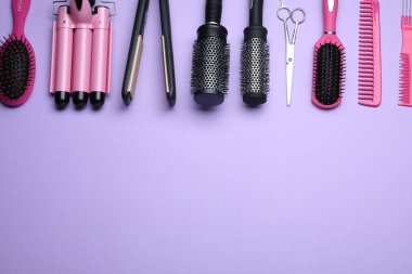 Flat lay composition of professional hairdresser tools on lilac background, space for text