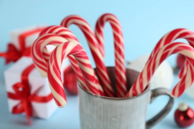 Christmas candy canes on light blue background, closeup