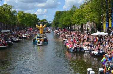 AMSTERDAM, NETHERLANDS - AUGUST 06, 2022: Many people in boats at LGBT pride parade on river