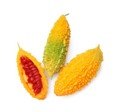Whole and cut ripe bitter melons on white background, top view