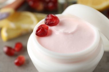 Natural facial mask and pomegranate seeds on table, closeup