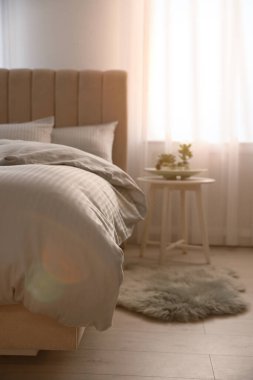 Pencereye yakın yumuşak battaniyeli rahat bir yatak.