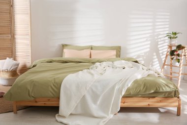 Şık oda içinde yumuşak battaniyeli büyük bir yatak.