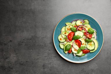 Tasty salad with cucumbers on grey table, top view. Space for text