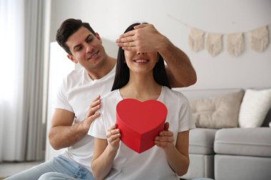 Erkek, evdeki sevgili karısına hediye sunar. Sevgililer Günü kutlaması