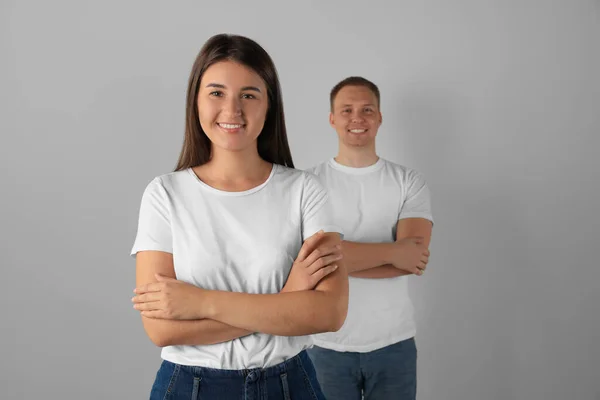 Portrait of happy young woman and man on light background