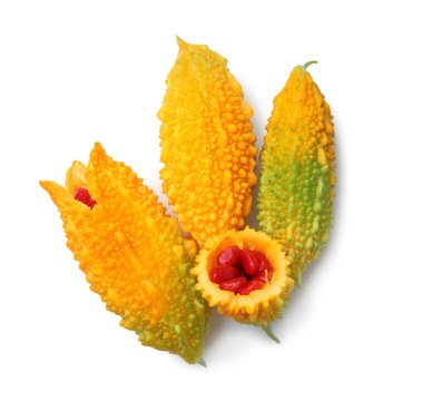 Whole and cut fresh ripe bitter melons on white background, top view