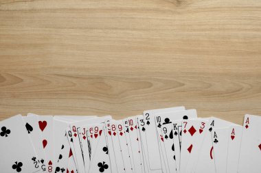 Deck of playing cards on wooden table, flat lay. Space for text