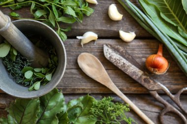 Flat lay composition with different herbs, rusty scissors and spoon on wooden table